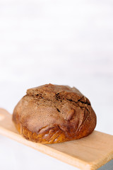 Fresh homemade crisp brown bread. Freshly baked bread on wooden cutting board. 
