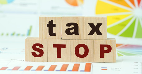 tax stop inscription on wooden blocks postponement of fee business concept