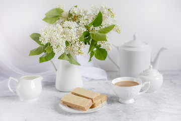Still life :white lilac, a Cup of coffee and an old book . Postcard good morning.
