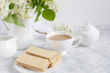 Still life :white lilac, a Cup of coffee and an old book . Postcard good morning.