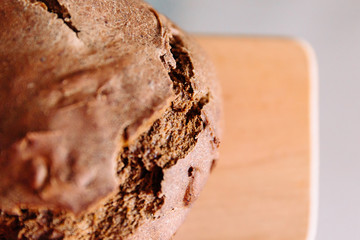 Fresh homemade crisp brown bread. Freshly baked bread on wooden cutting board. 