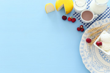 Top view photo of dairy products over pastel blue background. Symbols of jewish holiday - Shavuot