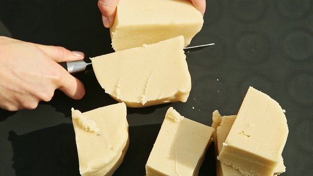 top view female hands slice by big knife small cubes of white marzipan mass