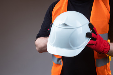 Construction helmet close-up. Construction concept. White construction helmet in the hands of a...