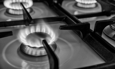 Burning blue flames gas. Focus on the front edge of the gas burners.