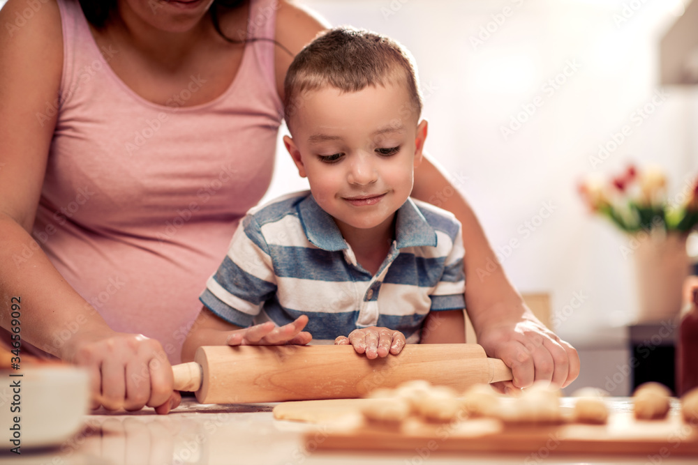 Poster pregnant woman and son making cookies.