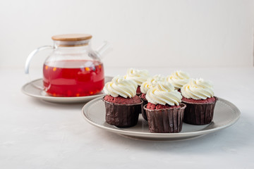 Red velvet cupcakes with white cream on top.