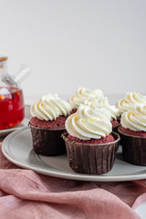 Red velvet cupcakes with white cream on top.