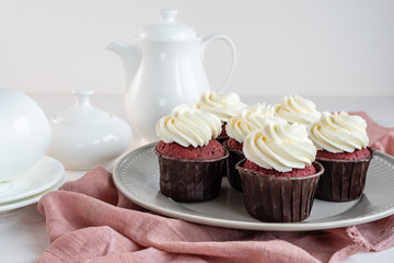 Red velvet cupcakes with white cream on top.