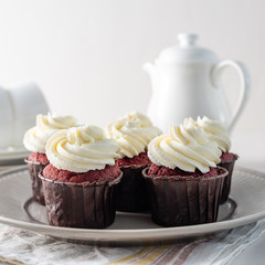 Red velvet cupcakes with white cream on top.
