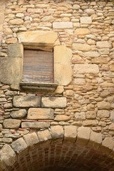Arch on stone wall in village of Girona province, Spain