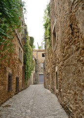 Medieval narrow stone alley in village  of Girona province, Spain