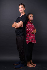 Portrait of young multi ethnic couple together back to back