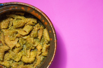 Pork rinds in green salsa with refried beans