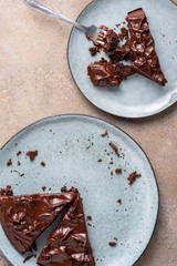 Serving brownie of triangular shape with ganache cream. Top view, flat lay, light background.