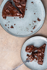 Serving brownie of triangular shape with ganache cream. Top view, flat lay, light background.