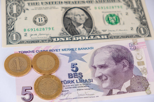 One American dollar and five Turkish Lira banknotes and three turkish  coins. Turkish lira depreciates against the US dollar