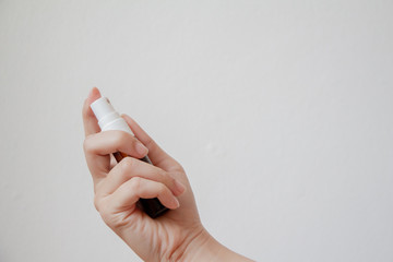 Woman holding oral spray on white background. Mouth and teeth care. Healthcare and medical concept.