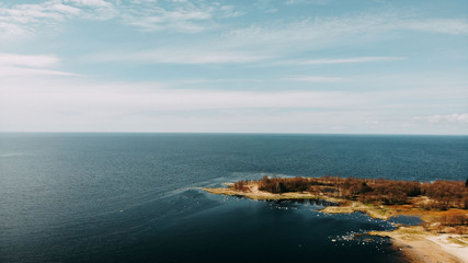 Fototapeta premium Ocean shore view from quadcopter, sand and rocks on the sea coast. Ocean day card. Ocean shore top view