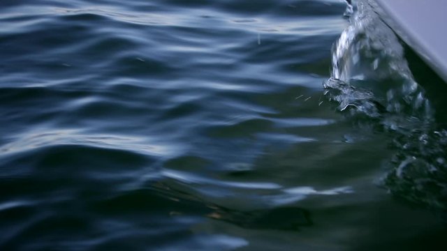 Sailboat bow moving through water with small waves in slow motion
