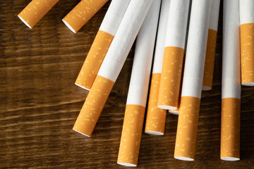 image of several commercially made cigarettes. pile cigarette on wooden dark background. or Non smoking campaign concept, tobacco. top view