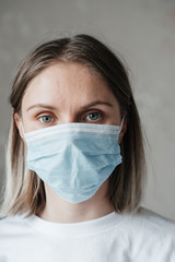.young girl with short hair in a white t-shirt in a mask, at home, close-up. Coronavirus. Quarantine