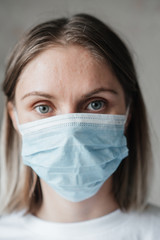 .young girl with short hair in a white t-shirt in a mask, at home, close-up. Coronavirus. Quarantine