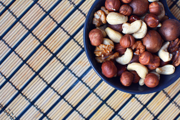 Hazelnuts, macadamia, cashews and walnuts in a bowl. Nuts close up. Delicious vegetarian snack.