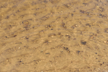 .river bank close up water sand stones