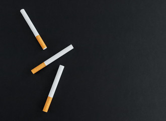 Three cigarettes on a black background. View svrhu and place for text.
