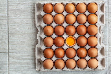 Whole brown chicken eggs and one broken egg