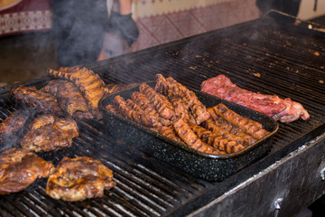 Chef preparing meat on the grill, during outdoor outside food festival