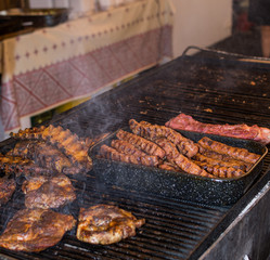 Chef preparing meat on the grill, during outdoor outside food festival
