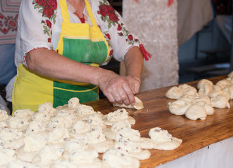 Traditional east european woman in authentic clothing kneading bread dough for 