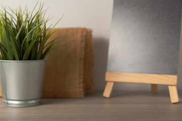Minimal blurred background for present product on the table with flower pot and blackboard