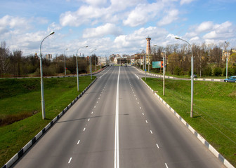 The road leads to a quiet residential area on a Sunny spring day.