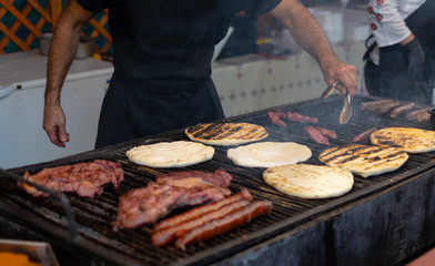 Chef preparing meat on the grill, during outdoor outside food festival