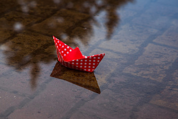 
colored paper ship floats in water