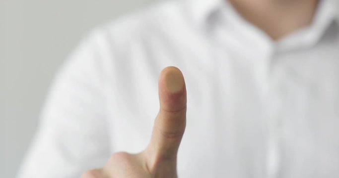 Man is touching transparent screen surface for digital scanning of fingerprint. Biometric scanner concept. Identification of person using thumbprint. Security scanning of finger unlock applications.