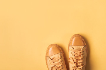 Yellow mustard sneakers on orange background. Minimal Spring summer fashion concept
