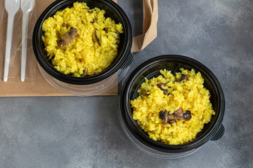 Italian risotto with champignons and parmesan. Food is delivered to your home in quarantine in disposable utensils. Rice is seasoned with turmeric and herbs. Copy space