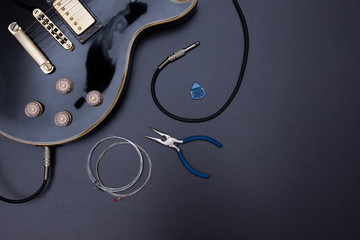 black guitar, strings and pliers