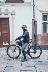 adult man with bike in the city with mask