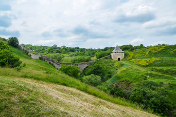 View of green hills and ruined walls on one of the entry gates of Khotyn Fortress on Dniester...