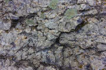 Raw gray granite rock texture background. Fragment of natural stone wall
