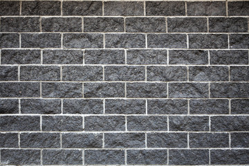 horizontal abstract black brick wall, natural stone texture, white cement between bricks, black brickwall for design