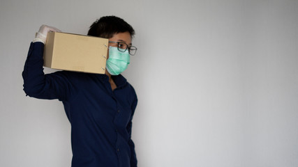 Delivery man employee wearing face mask gloves carrying package paper box. Service quarantine pandemic coronavirus virus 2019-ncov concept
