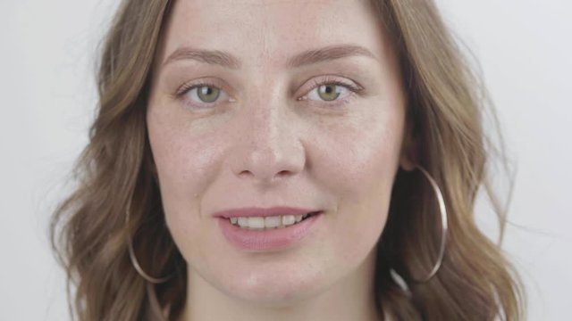 Close up of woman s face, female opening her beautiful green eyes, Attractive Ginger. Natural Beauty with Freckles. Gorgeous woman with long Eyelashes and Attractive Appearance. Slow motion. 4k