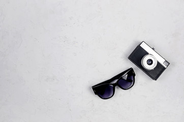 Monochrome Summer background with women's sun glasses and vintage camera