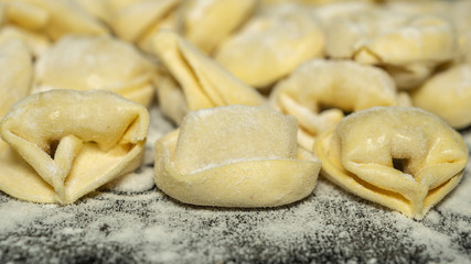 Close up to delicious tortellini a ring-shaped pasta from Italy. Traditionally they are stuffed with a mix of meat, parmigiano reggiano cheese, egg and nutmeg
